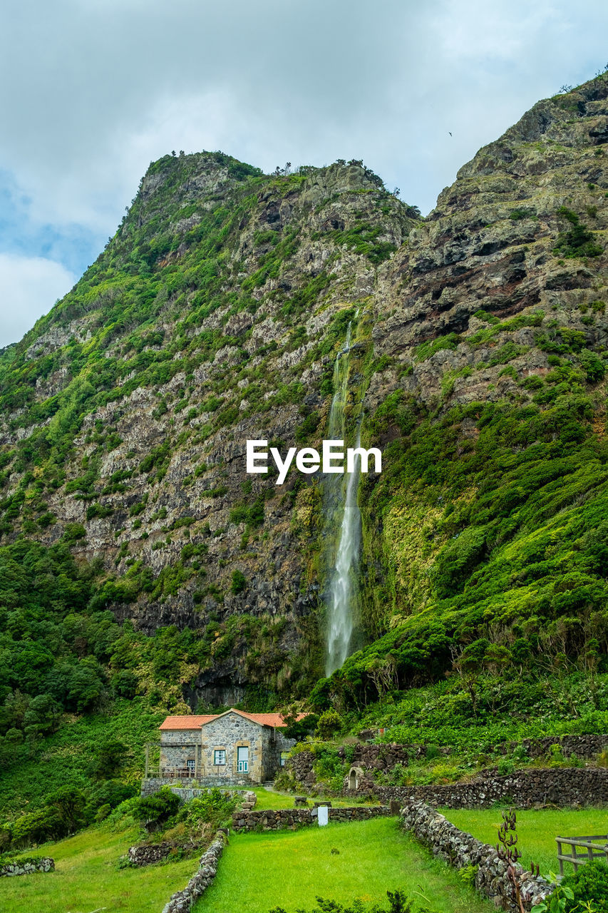 SCENIC VIEW OF WATERFALL ON MOUNTAIN