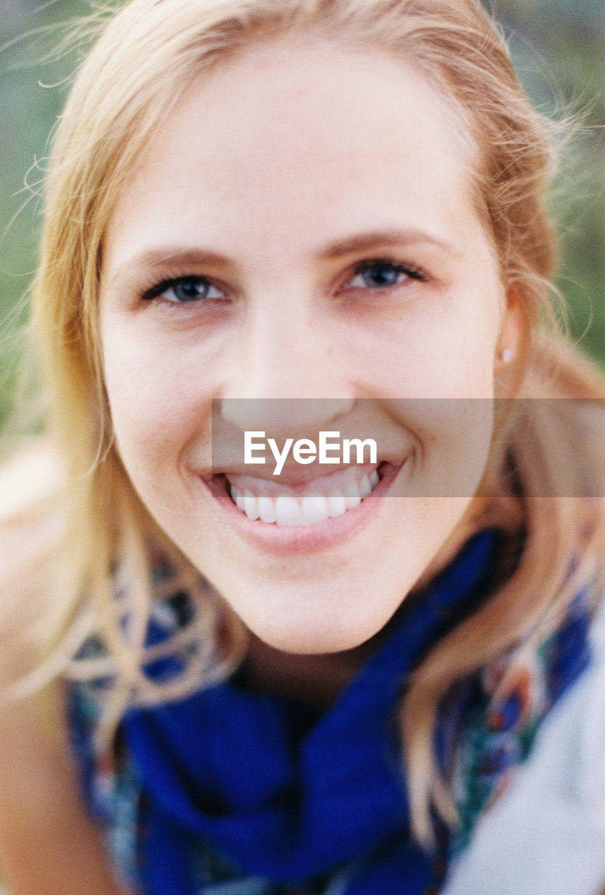 Close-up portrait of smiling young woman outdoors