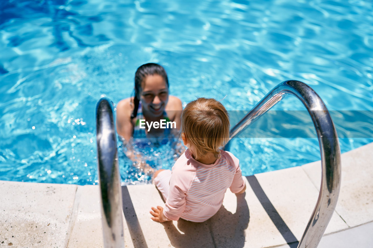 High angle view of woman looking at swimming pool