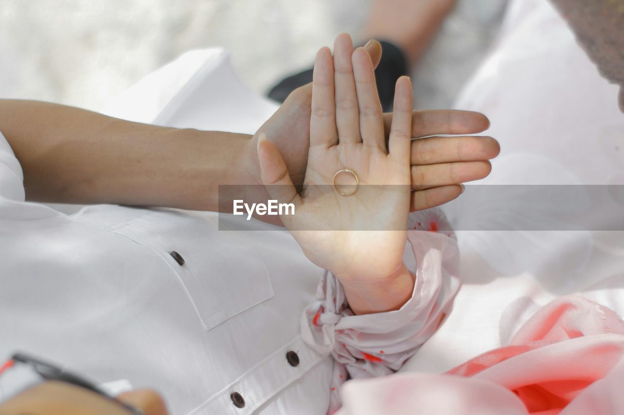 Close-up of couple holding wedding ring