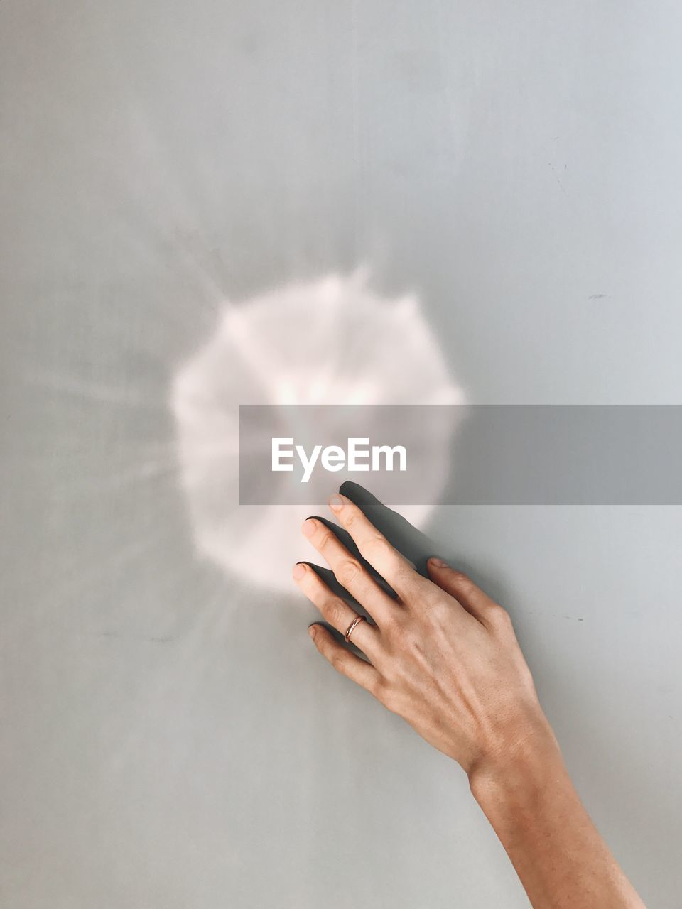 Cropped hand of woman touching wall