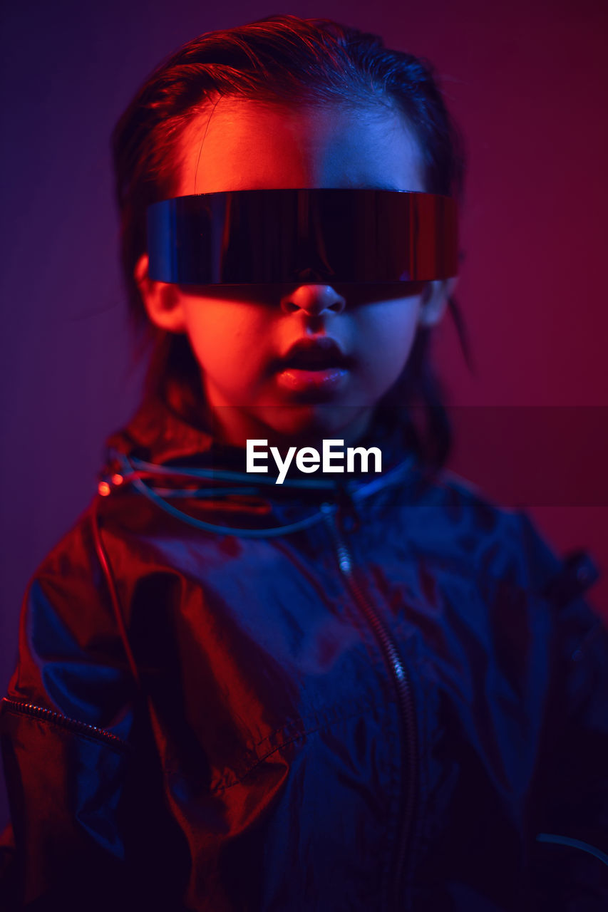 Portrait cyberpunk boy child in vr glasses in blue and red tones. game, virtual reality