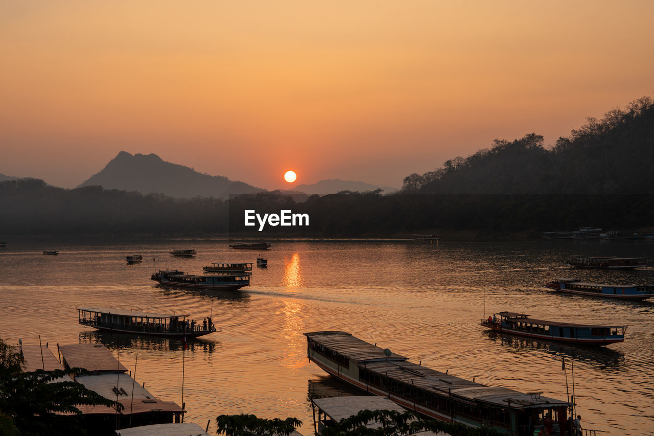 Wooden boats at the mekong river of luang prabang in laos southeast asia during the sunset time