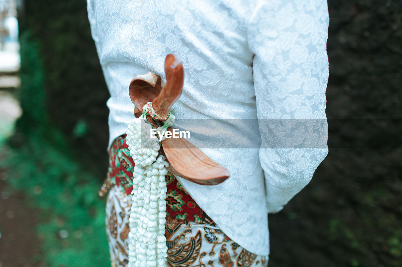 MIDSECTION OF WOMAN HOLDING UMBRELLA