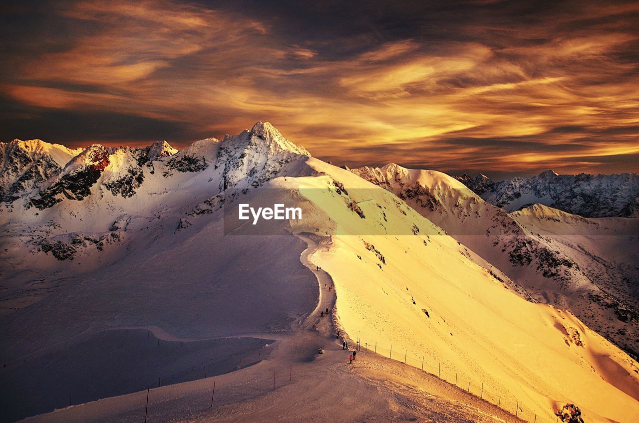 Scenic view of snowcapped mountains against sky during sunset