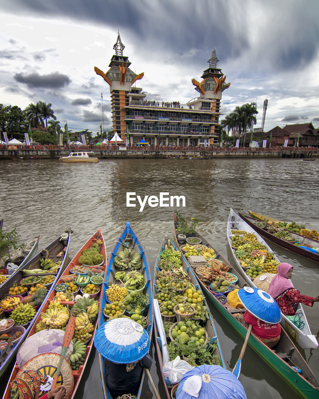 View of boats moored in lake against cloudy sky