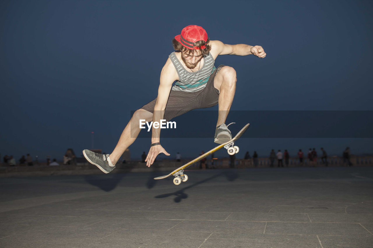 Young skateboarder flipping his board