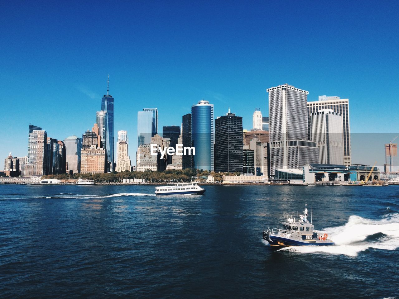 MODERN BUILDINGS BY SEA AGAINST CLEAR BLUE SKY