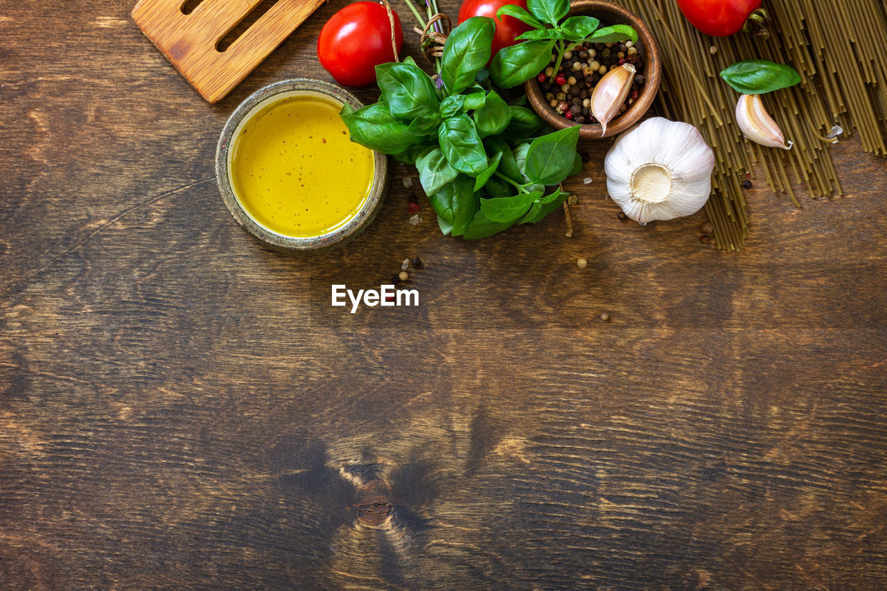 Ingredients for italy cuisine. spinach spaghetti, herbs, spices, olive oil and tomatoes.