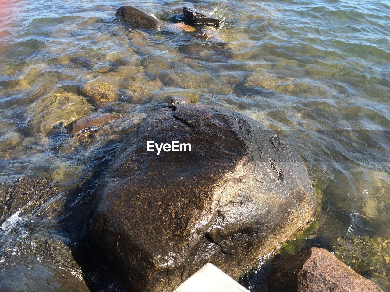 HIGH ANGLE VIEW OF WATER SPLASHING ON ROCKS