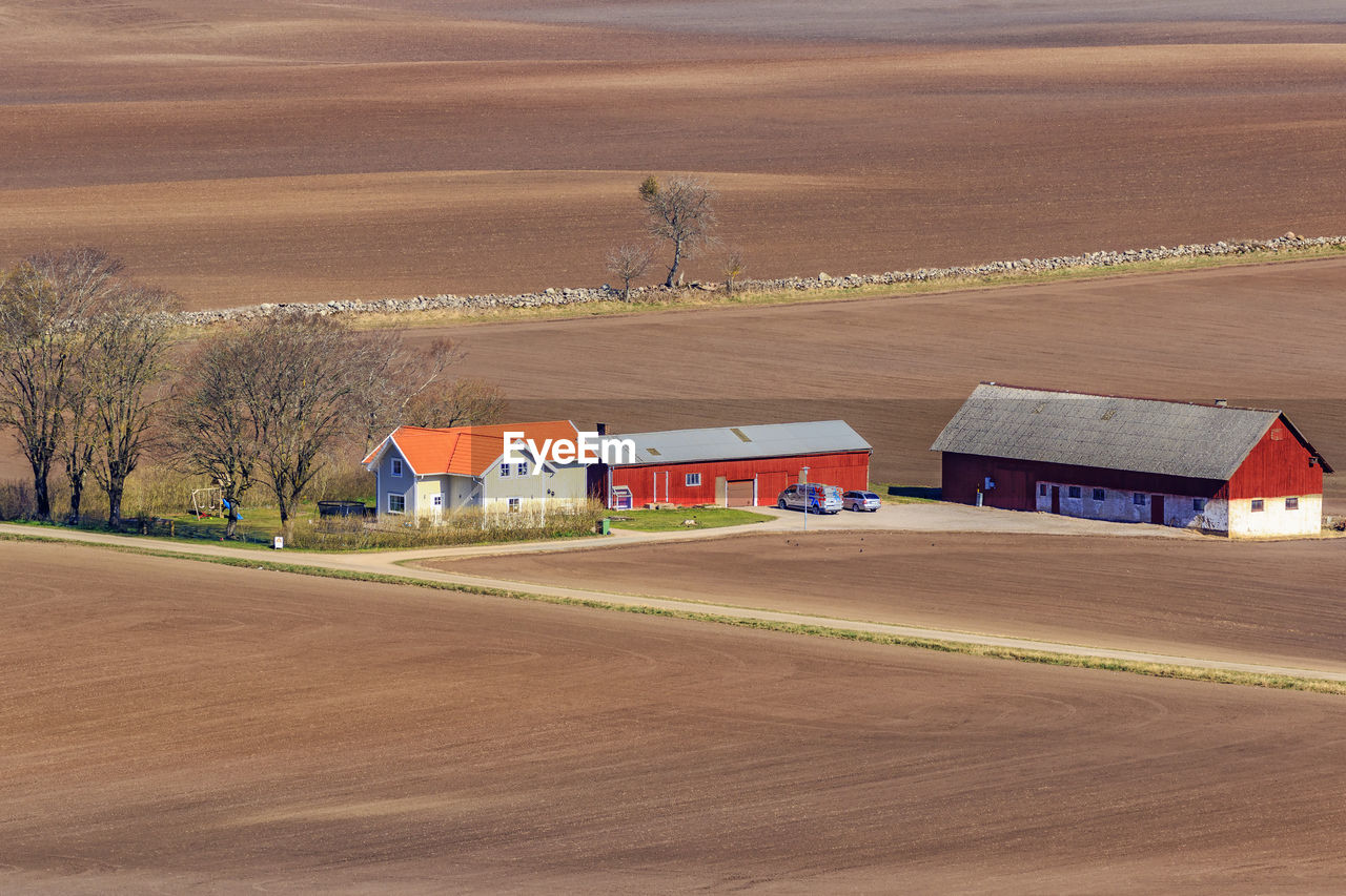 Houses on field by road against sky