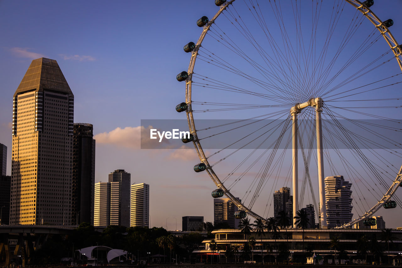 A view of singapore flyers with skyscrappers during golden hour 