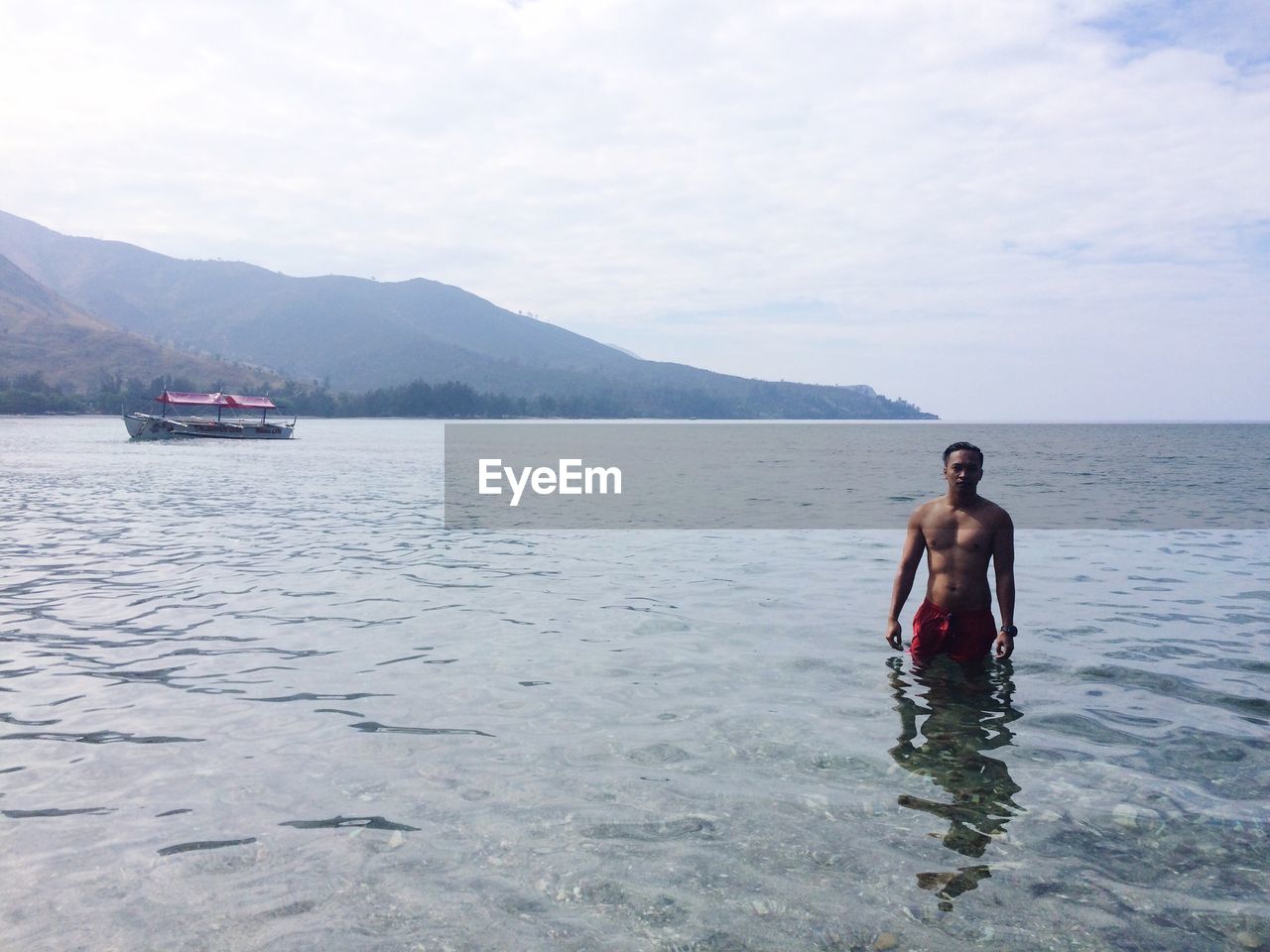 Man standing in sea against sky