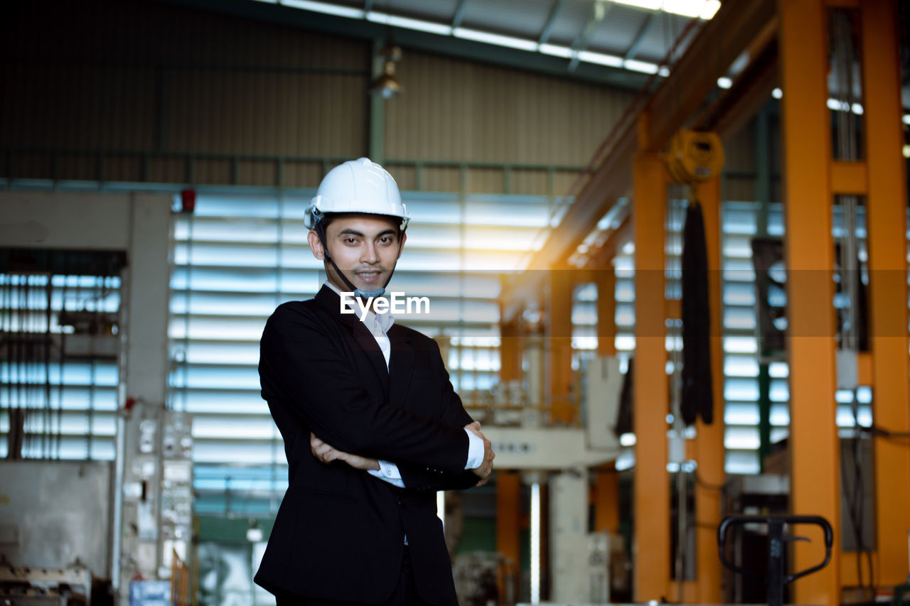 YOUNG MAN WEARING HAT STANDING IN OFFICE