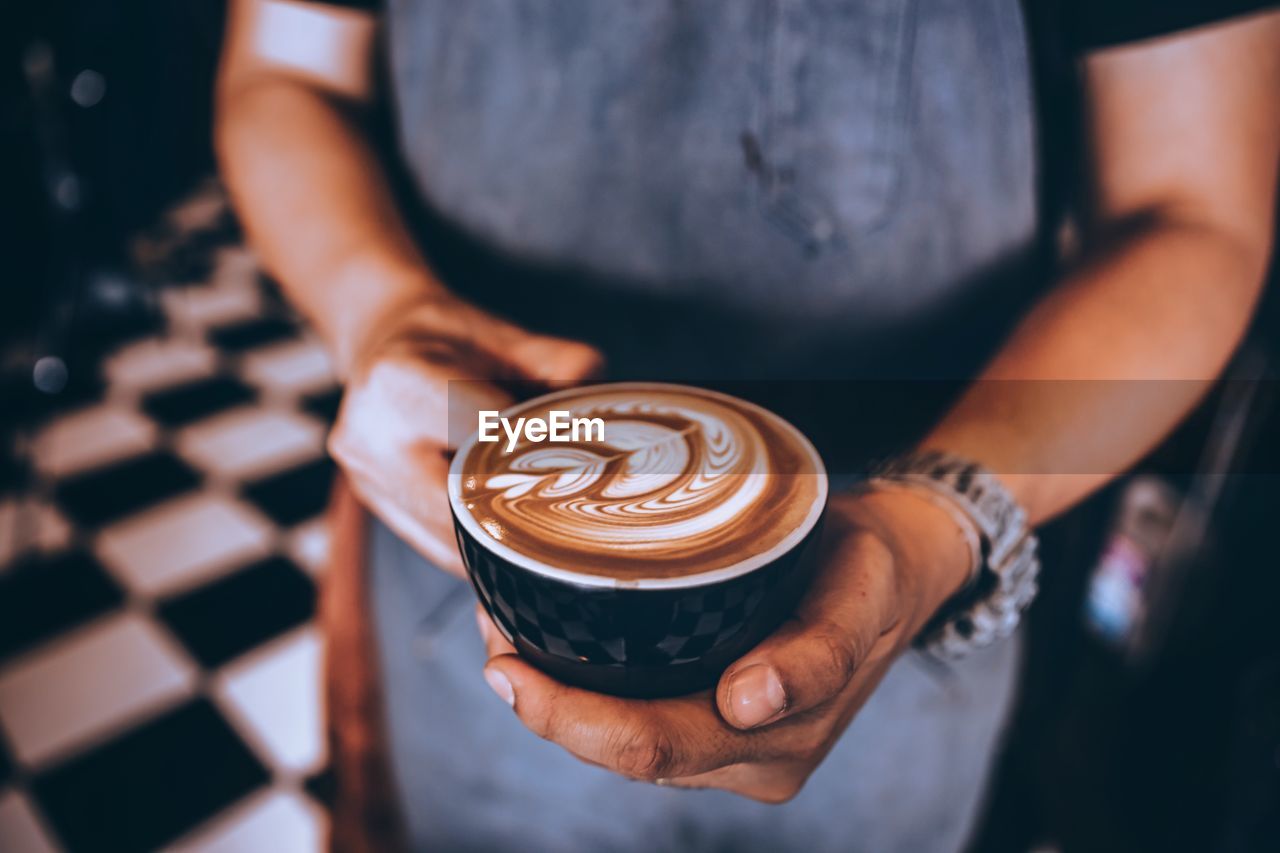 Midsection of man holding coffee