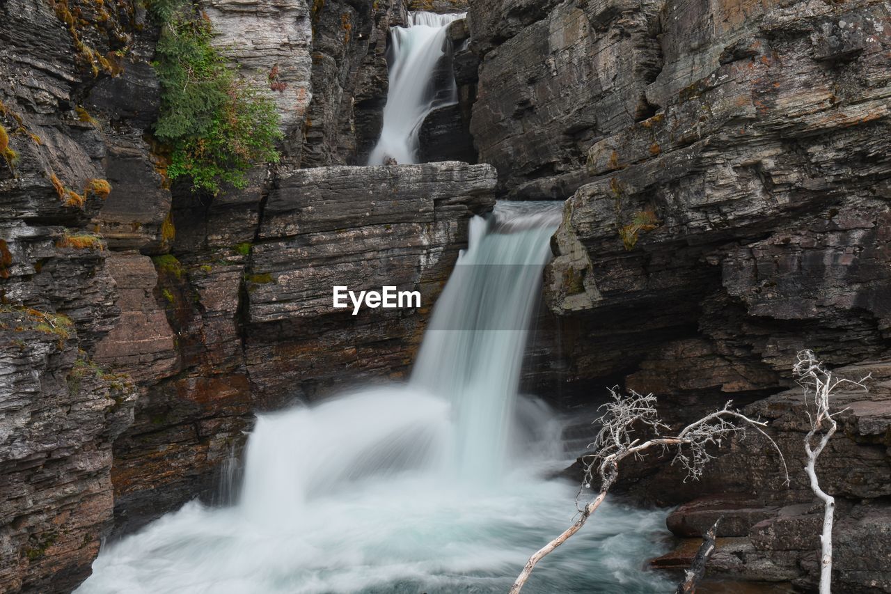 VIEW OF WATERFALL AGAINST ROCK FORMATION