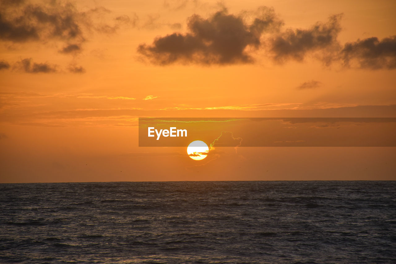 Scenic view of sea against orange sky