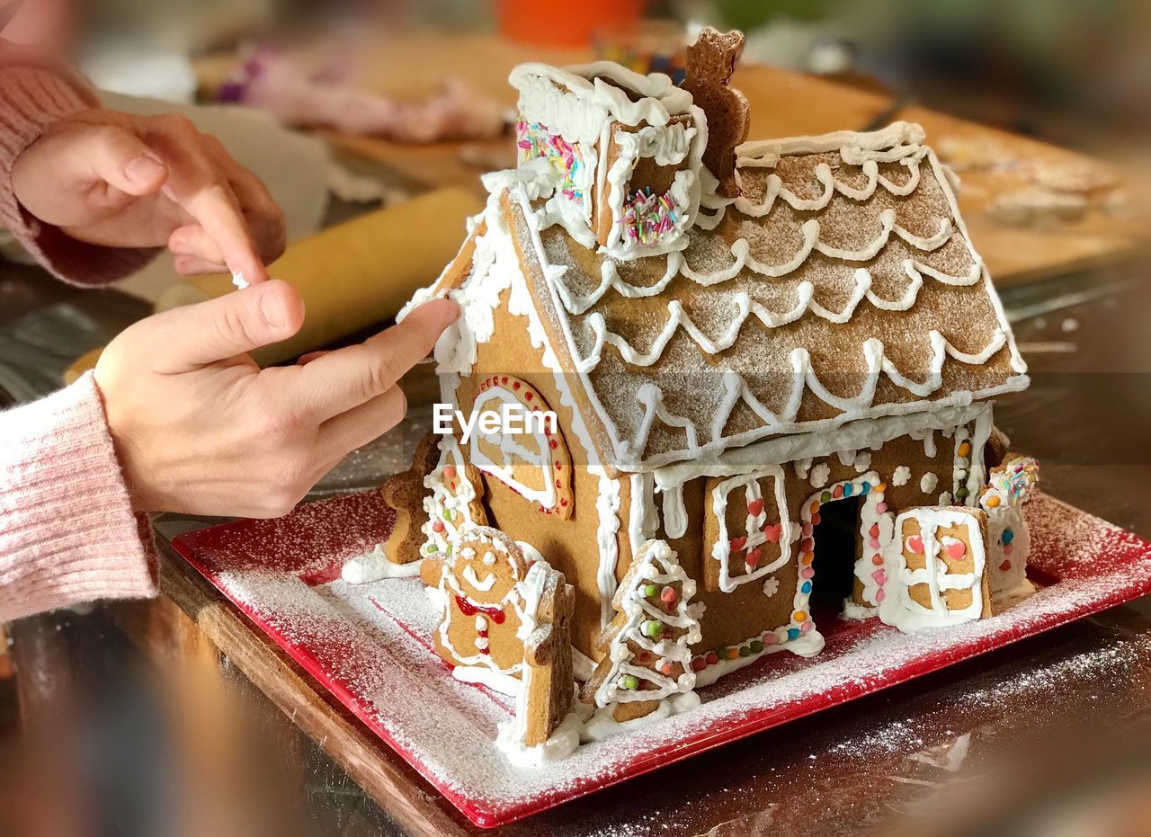 Hand of young man making gingerbreadhouse