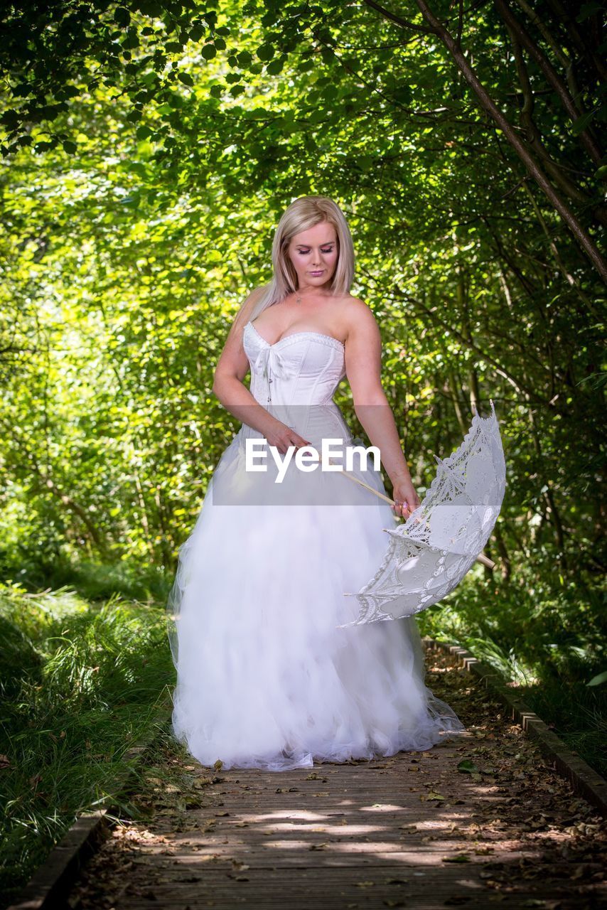 Bride standing against plants