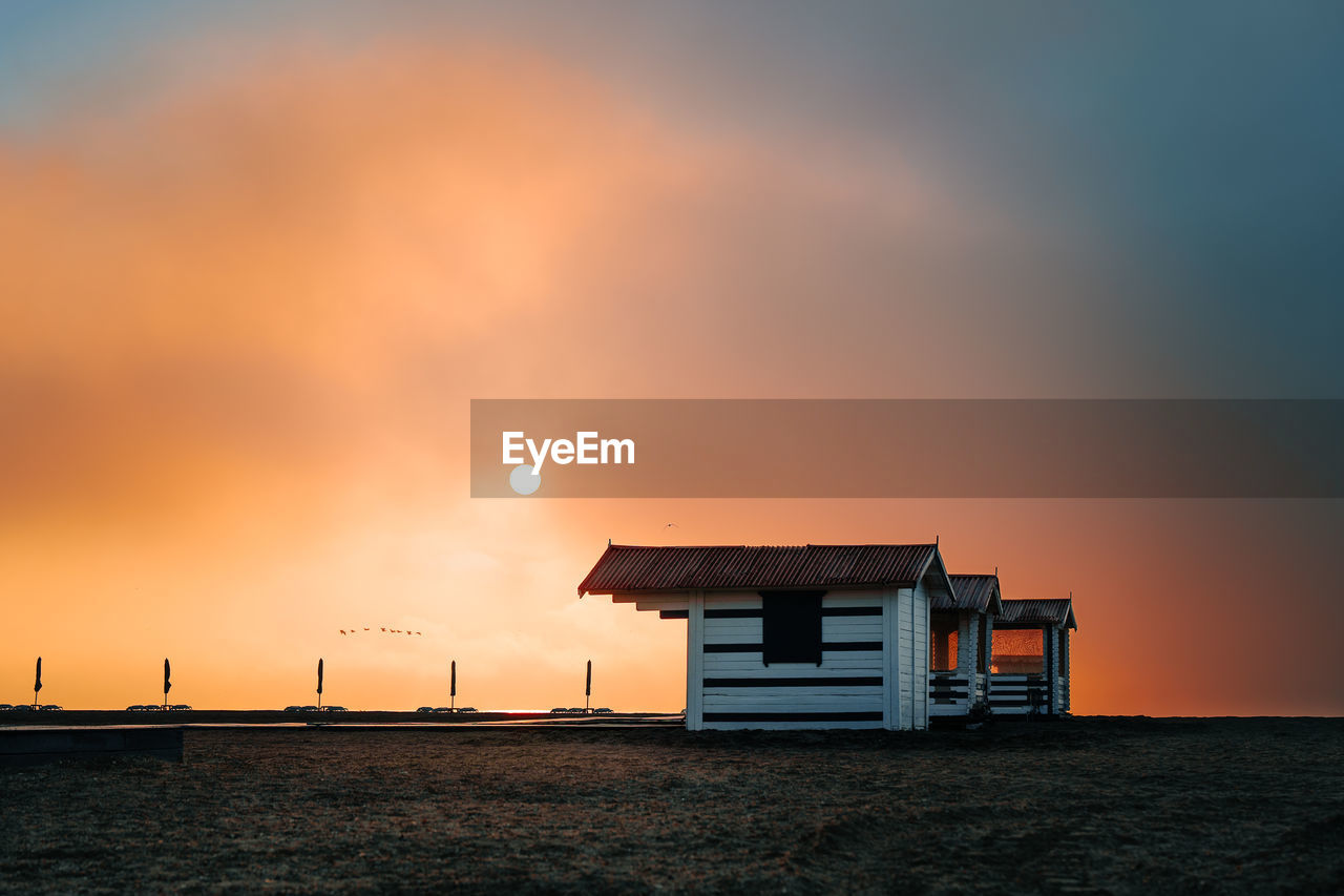 Beach hut on foggy shore at sunrise