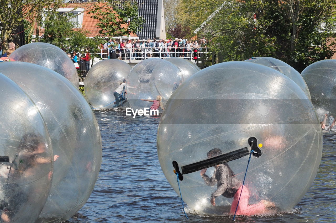 Children zorbing on lake