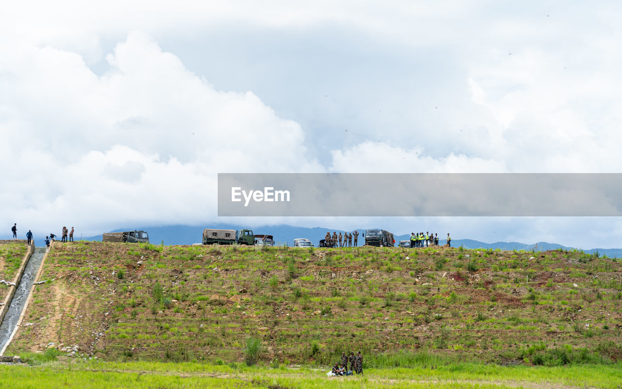 sky, cloud, environment, landscape, hill, nature, land, field, rural area, grass, plant, horizon, agriculture, travel, scenics - nature, plain, rural scene, animal, outdoors, day, beauty in nature, grassland, no people, tourism, animal themes, travel destinations, architecture, prairie, mammal, green, meadow, pasture, animal wildlife, transportation, group of animals, non-urban scene, livestock, social issues, water, domestic animals