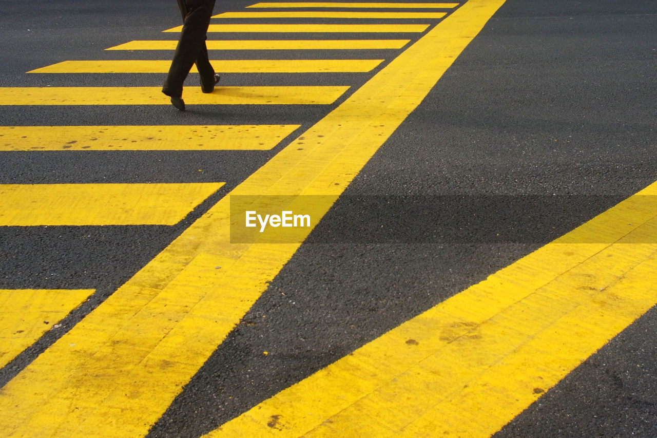 Low section of woman walking on zebra crossing