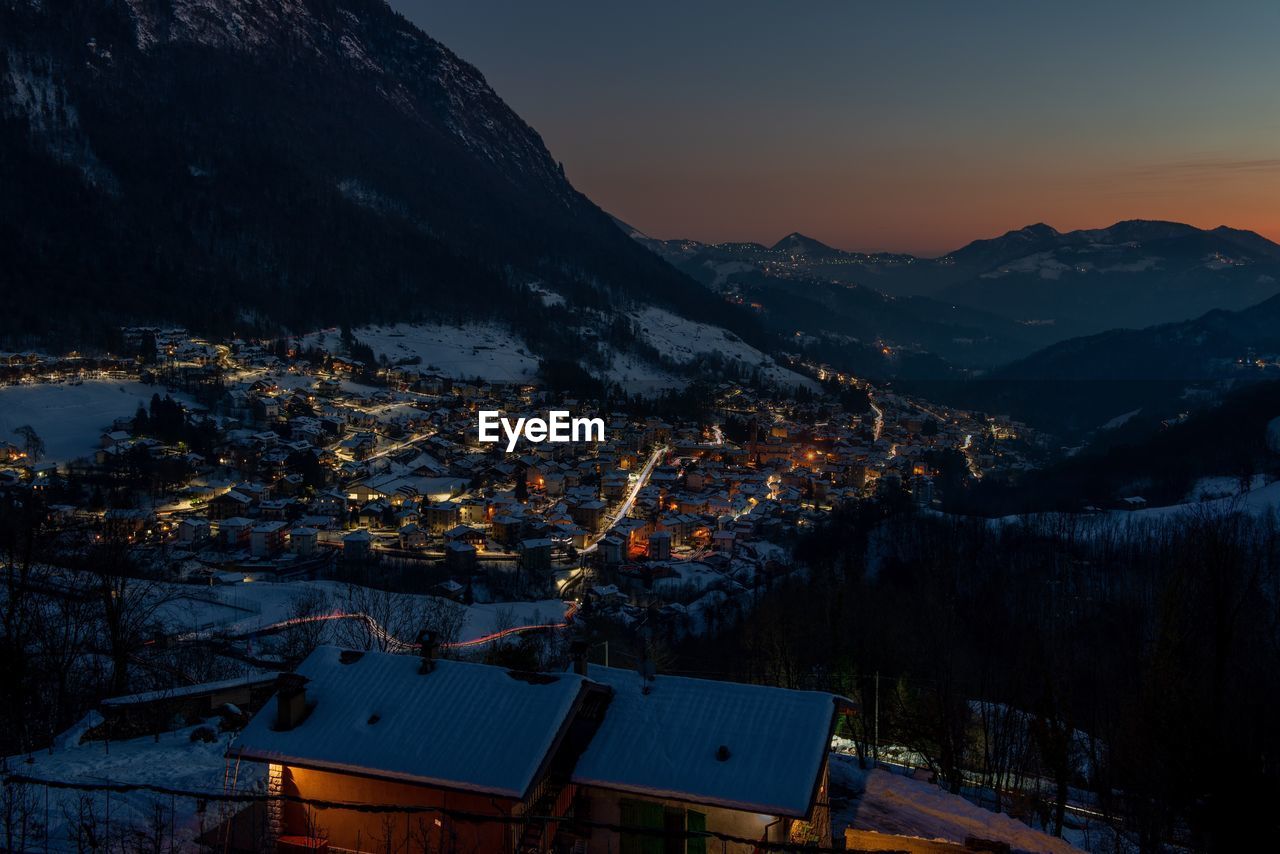 Mountain village icon snow at sunset