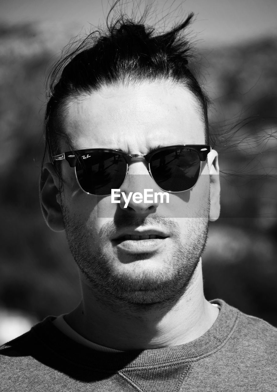 PORTRAIT OF YOUNG MAN WEARING SUNGLASSES