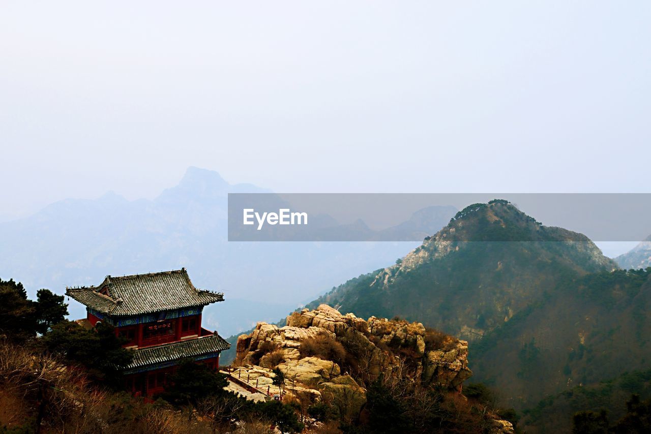 BUILDING BY MOUNTAINS AGAINST SKY