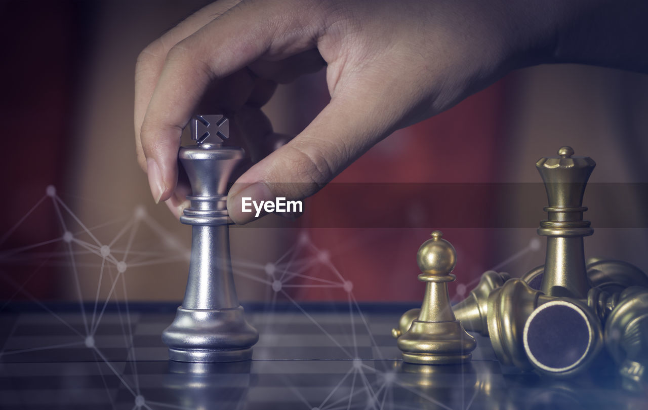 CLOSE-UP OF HAND PLAYING WITH CHESS