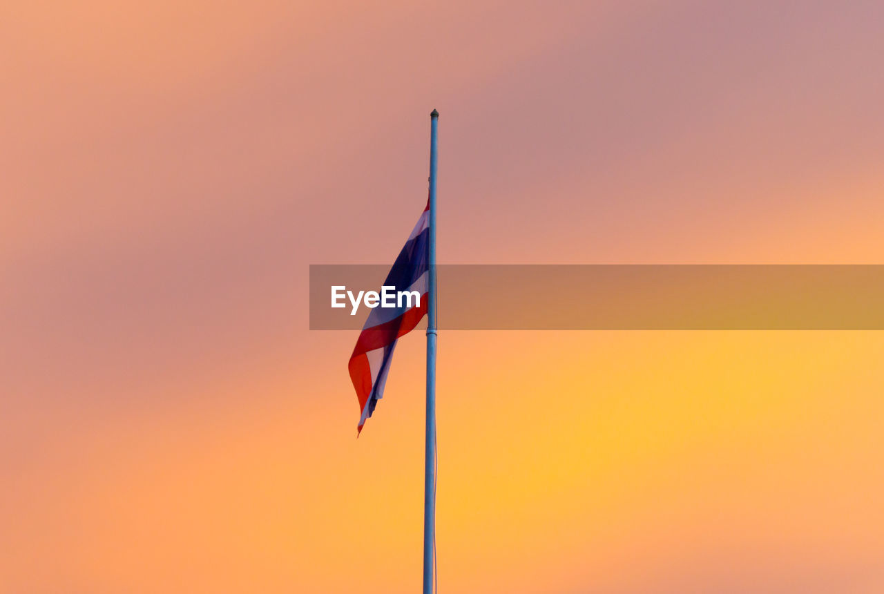 Low angle view of thai flag against sky during sunset