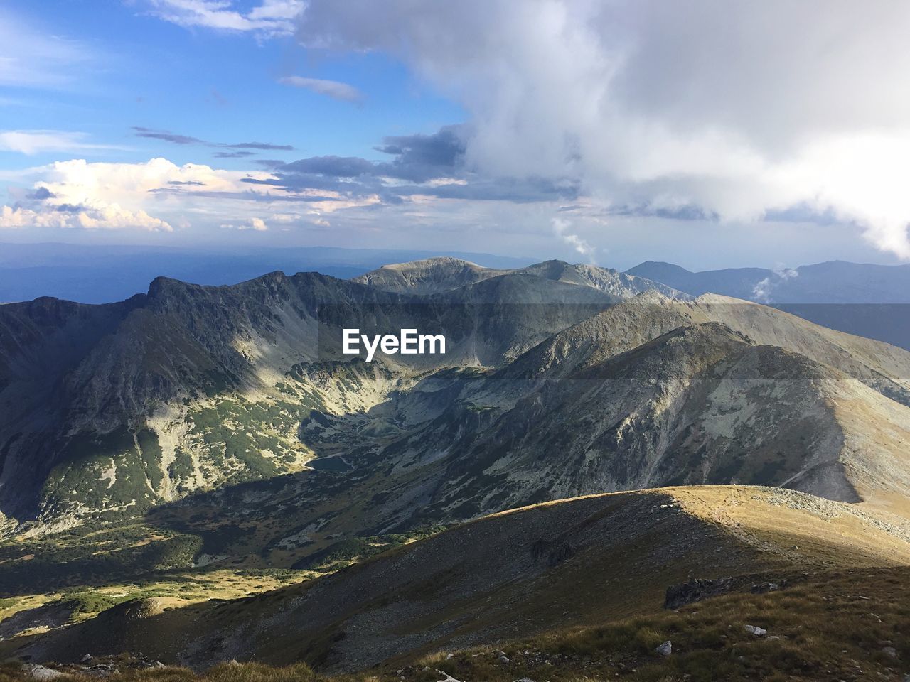 Scenic view of mountains against cloudy sky