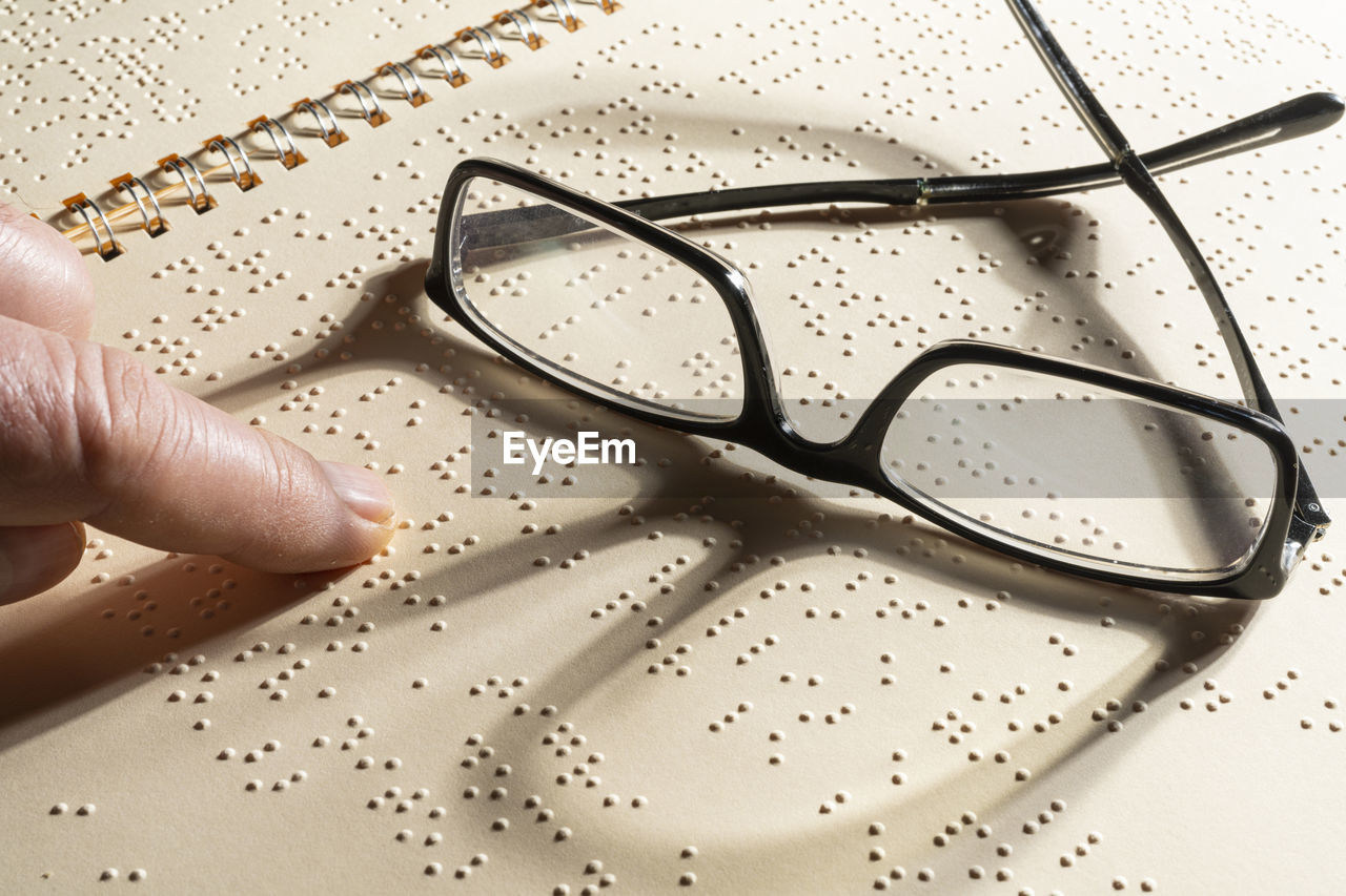A pair of eyeglasses on a page written in braille, the embossed tactile reading system for the blind