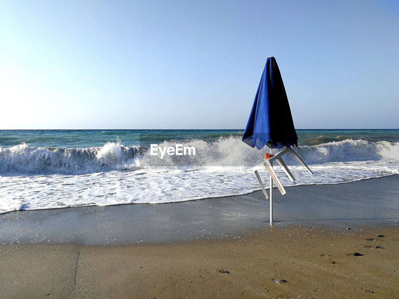 Windy beach with abandoned umbrella