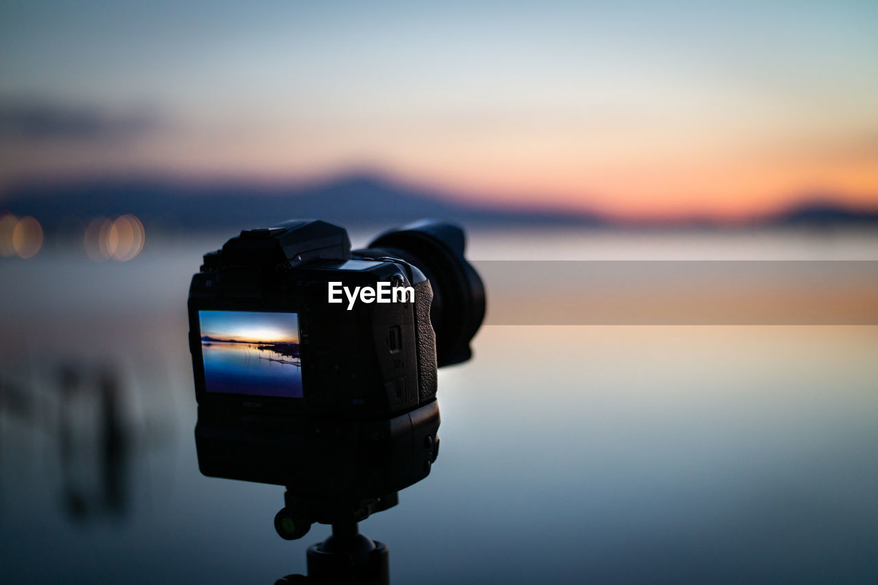 Landscape photoshoot camera on tripod at sunset