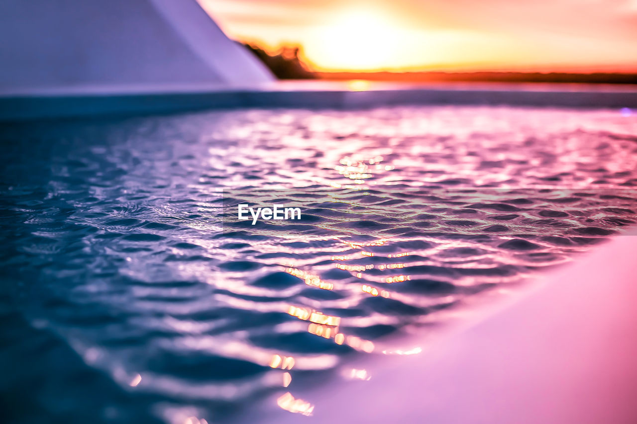 CLOSE-UP OF SEA AGAINST SUNSET SKY