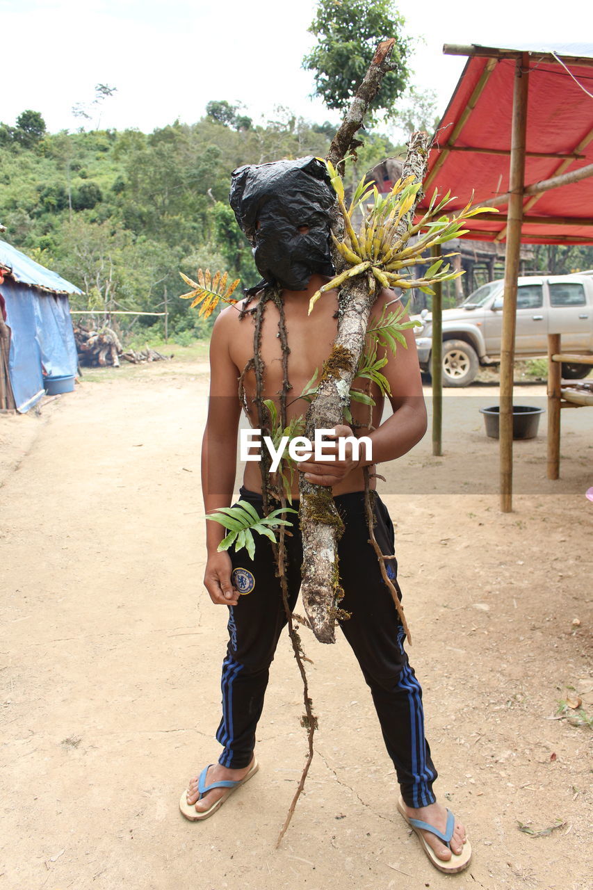 FULL LENGTH OF BOY STANDING ON TREE