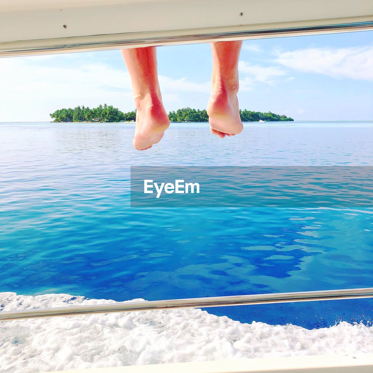 LOW SECTION OF PERSON ON SWIMMING POOL AGAINST SKY