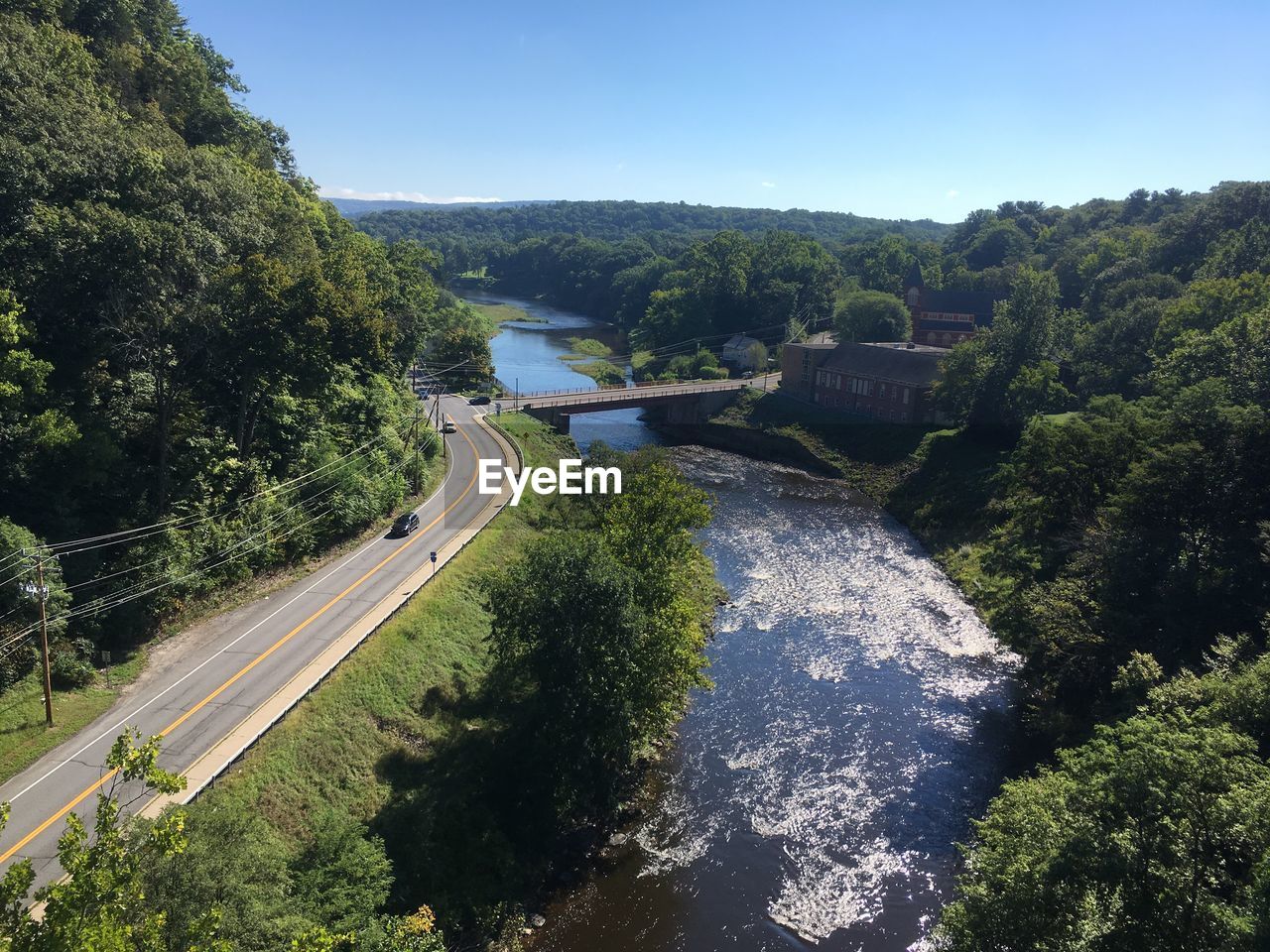 HIGH ANGLE VIEW OF RIVER AMIDST TREES AND PLANTS AGAINST SKY