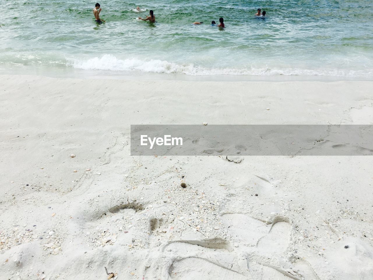 PEOPLE ON BEACH BY SEA