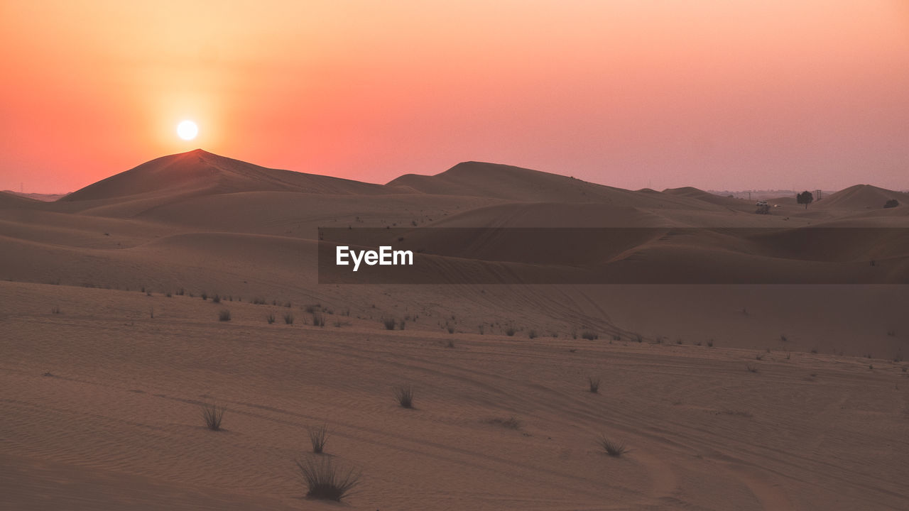 Scenic view of desert against sky during sunset