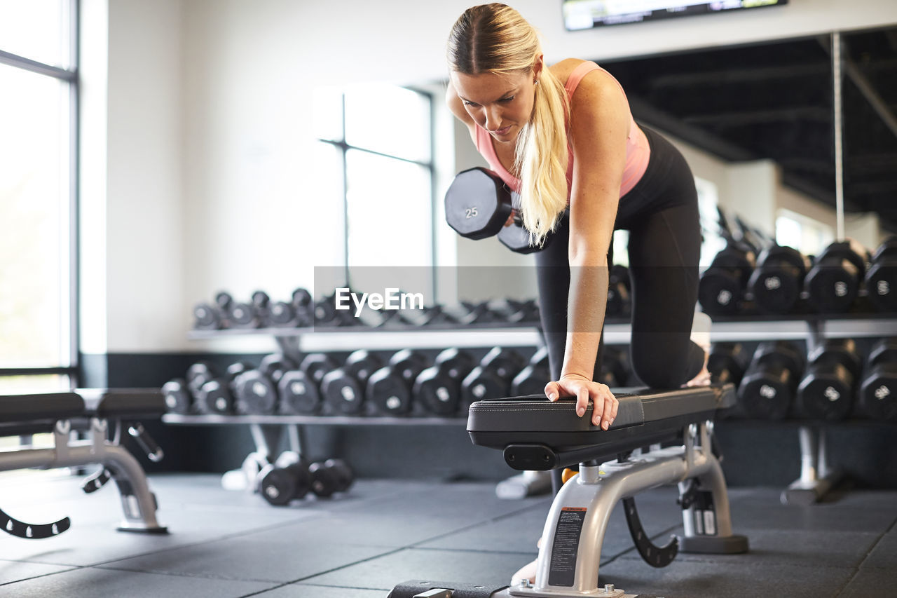 A blonde woman working out in a gym.