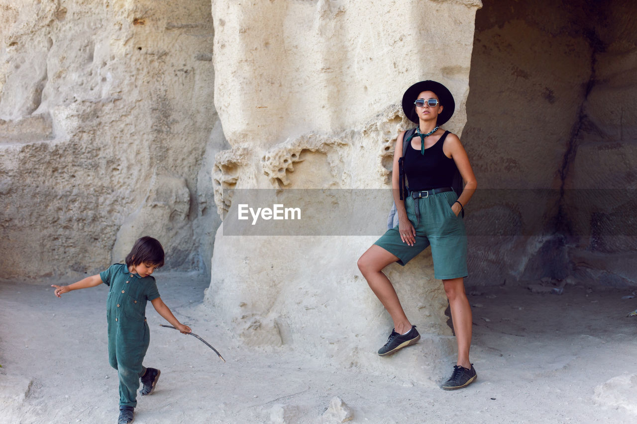 Mother and son travelers walk near a rock in the crimea