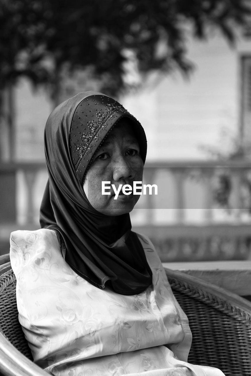 Disabled mature woman sitting on wicker chair