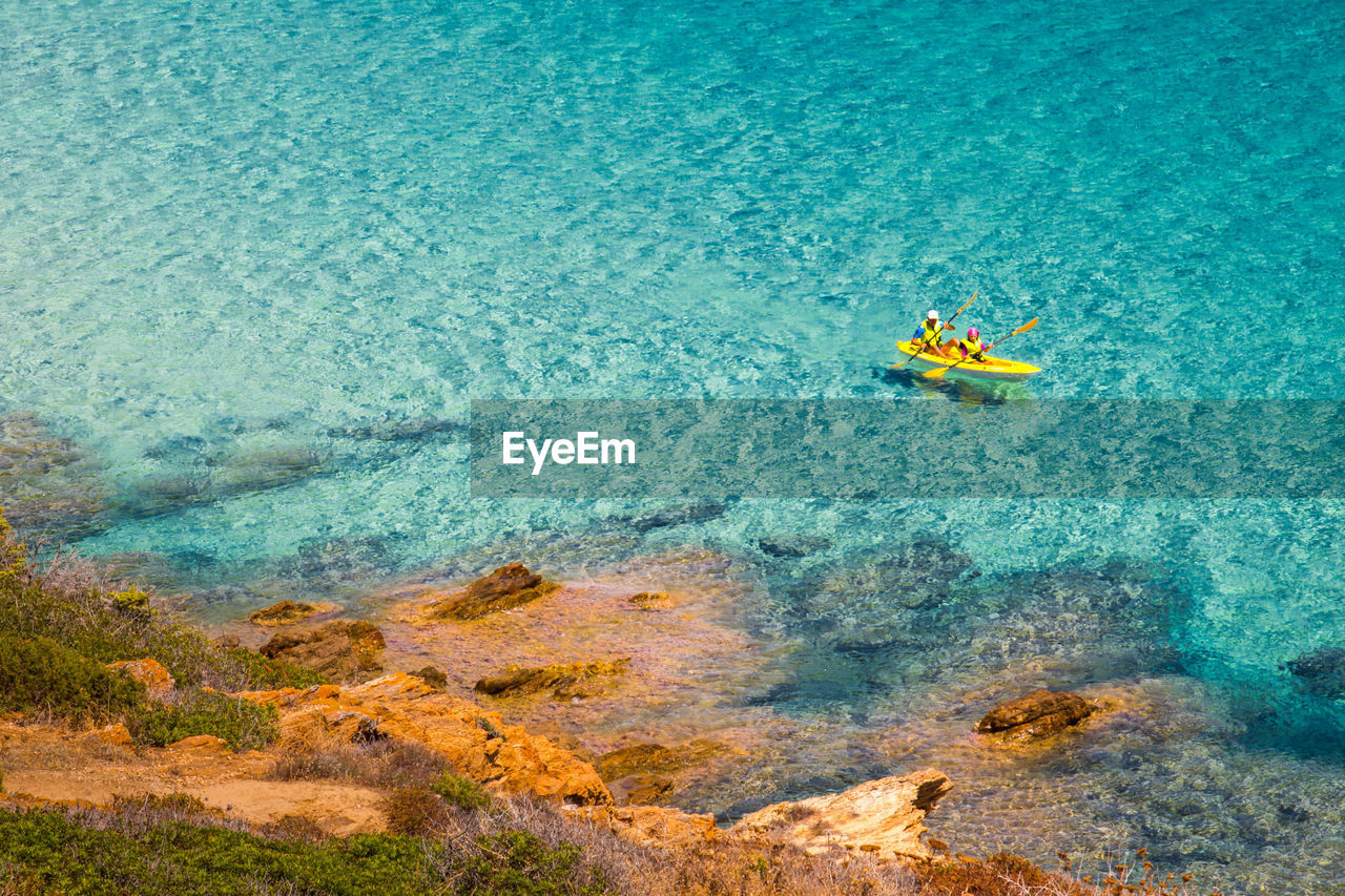 High angle view of people kayaking in sea