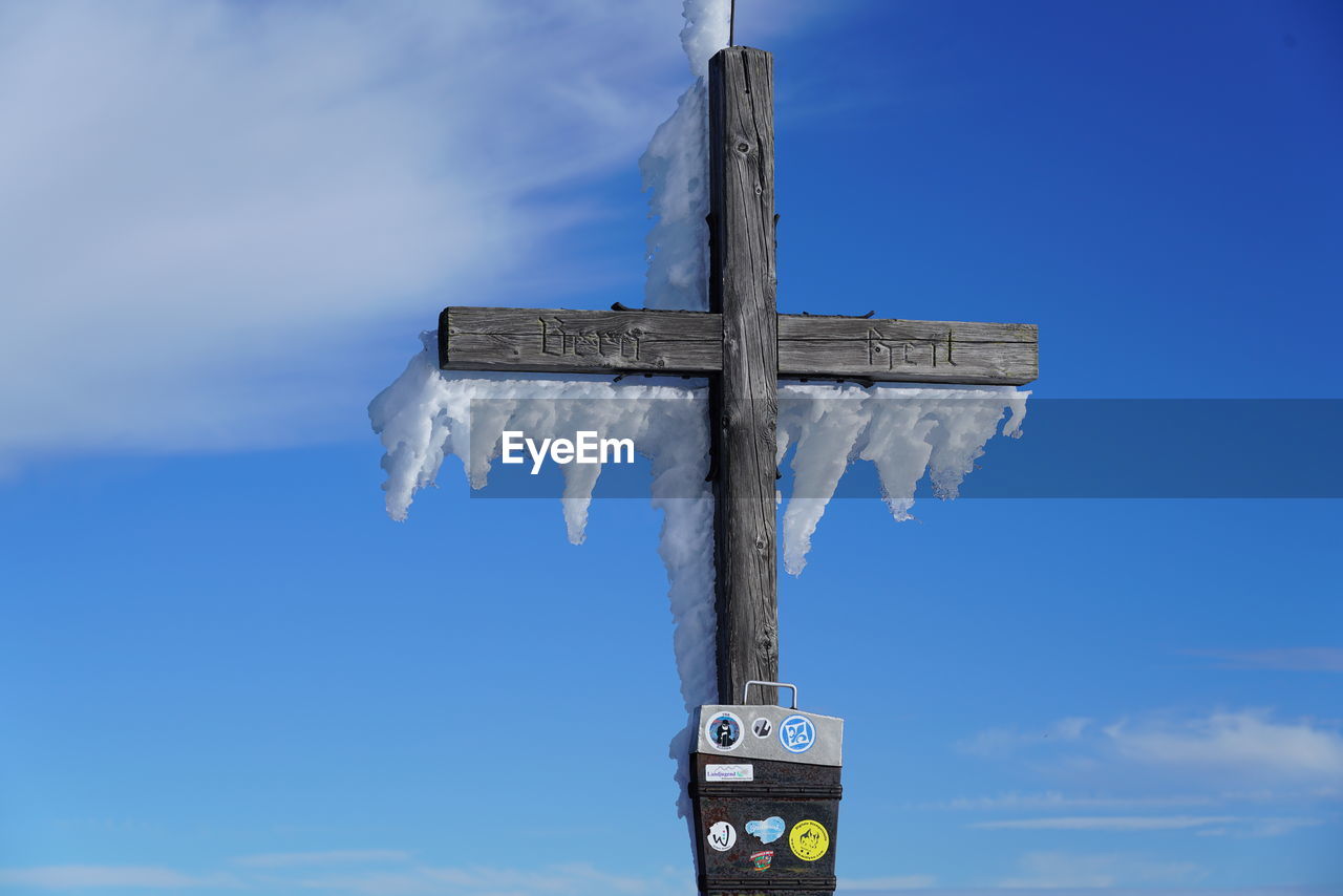 LOW ANGLE VIEW OF CROSS ON BEACH AGAINST SKY