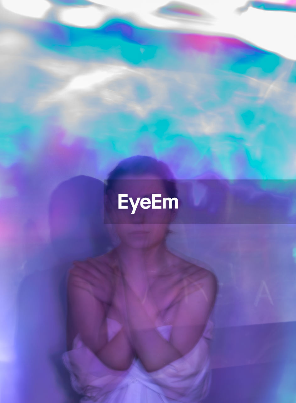 Multiple exposure of young woman in multi colored glass room