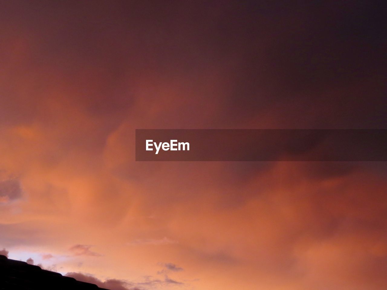 Low angle view of orange storm clouds