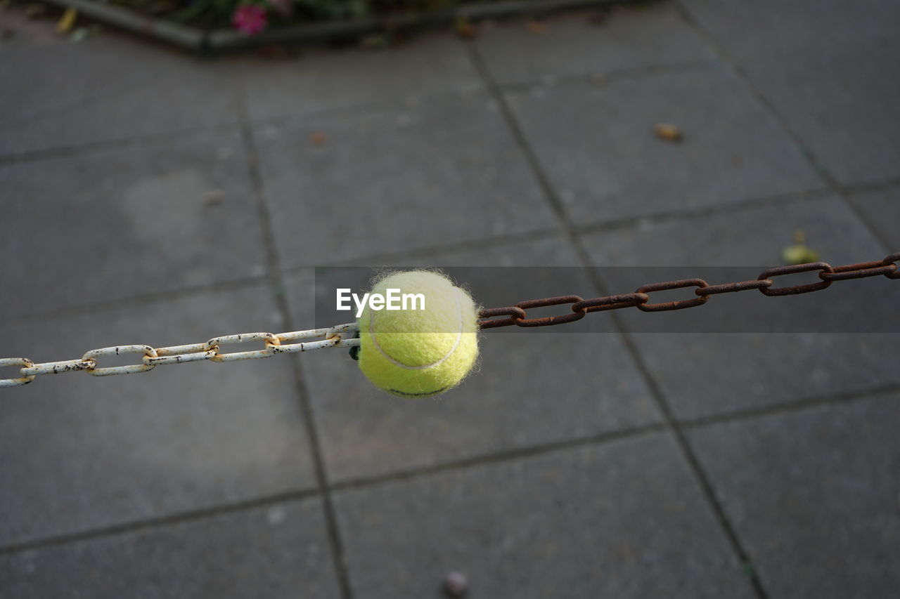 Close-up of yellow ball on  chain